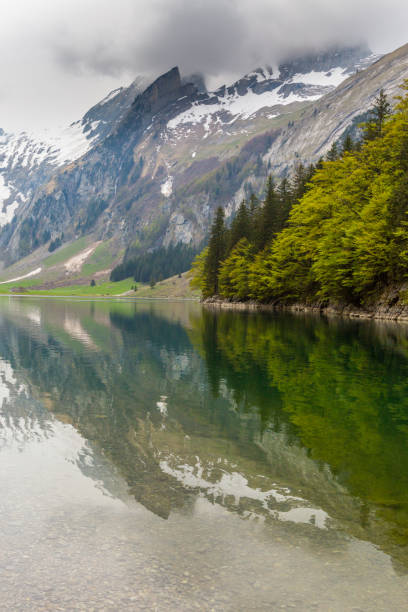 istock lake Seealpsee, reflected snowcapped mountain, clouds 1152435964