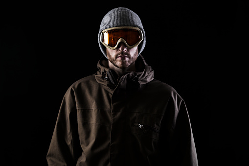 Man in winter sports clothing in studio with black background