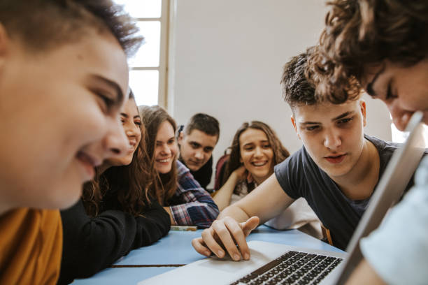 istock Group of teenagers talking and smiling while they are using laptop 1152438689