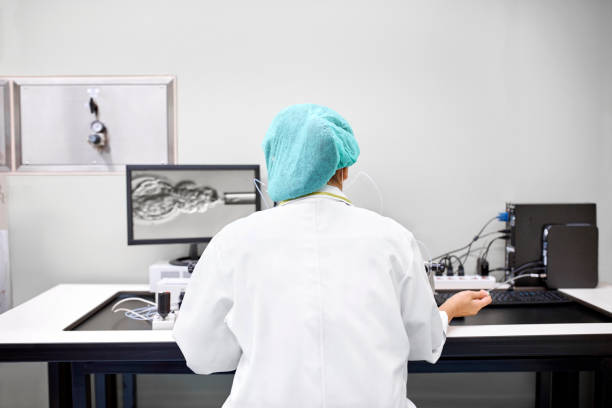 Laboratory technician performing in vitro fertilization Rear view of female laboratory technician performing in vitro fertilization of a human egg. Intracytoplasmic sperm injection. human fertility stock pictures, royalty-free photos & images