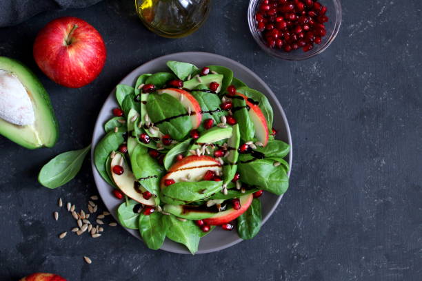 istock Fresh salad with spinach, avocado, apple, pomegranate and sunflowers seed on dark background. 1152441584