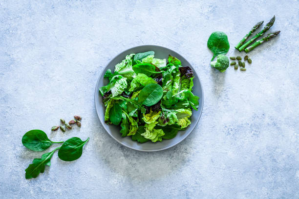 comer saudável: a salada verde fresca disparou de acima no fundo cinzento - arugula freshness food herb - fotografias e filmes do acervo