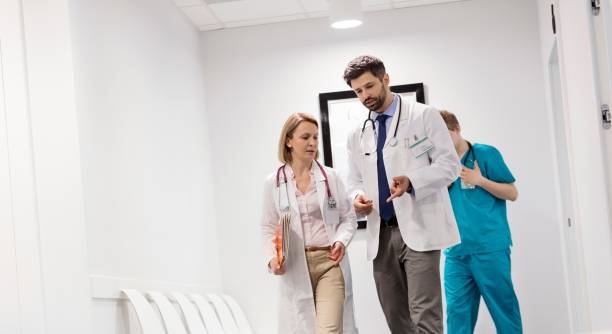istock Nurse walking behind doctors discussing at corridor in hospital 1152444231