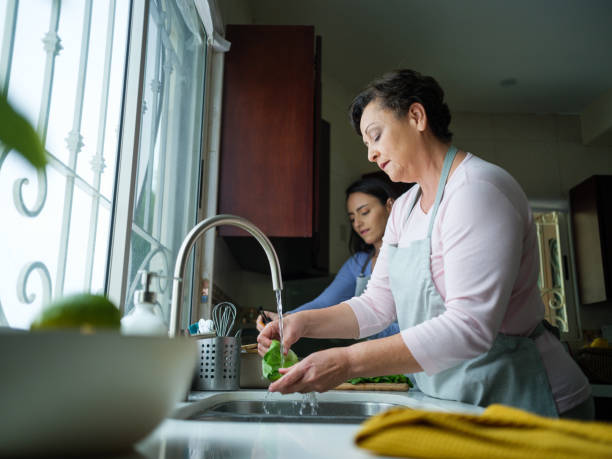 istock Older mother washing vegetables in the kitchen 1152444627