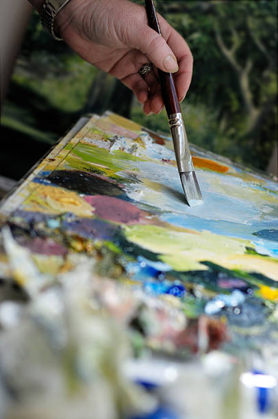 istock Artist working with oil paints on palette 115244549