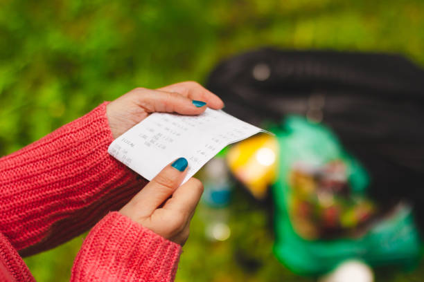 Closeup shot of woman holding and reading a receipt stock photo