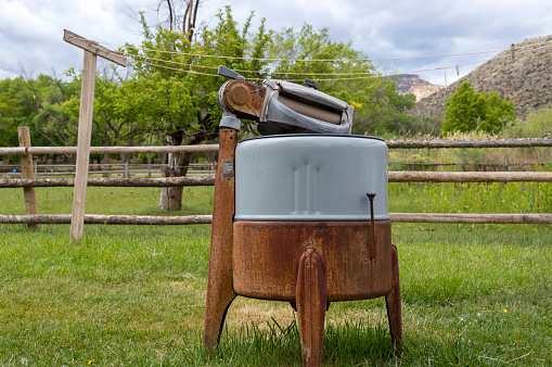This scene come from Fruita, the preserved settlement now in the middle of Capitol Reef National Park.  This old time washing machine and clothesline are on display near an orchard and pasture.  In the background are the red cliffs that surround the Fruita settlement.