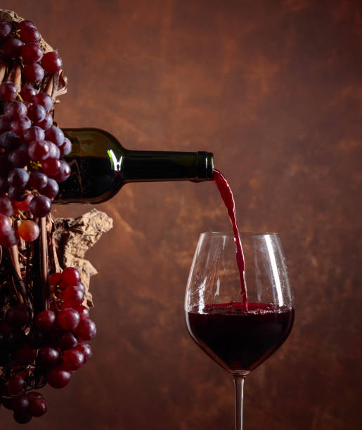 istock Red wine pouring from a bottle into a glass. 1152446145