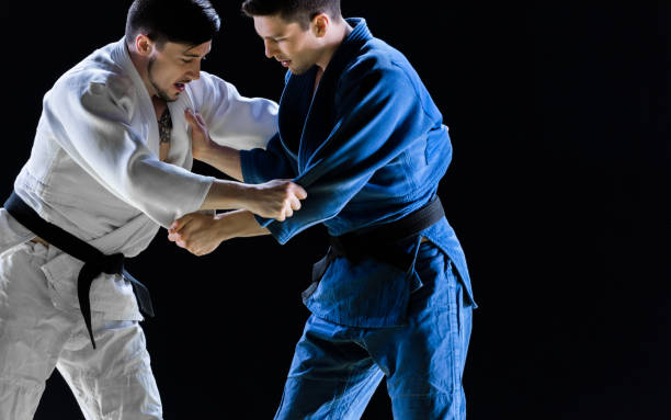 jugadores masculinos de judo compitiendo durante el partido - judo fotografías e imágenes de stock