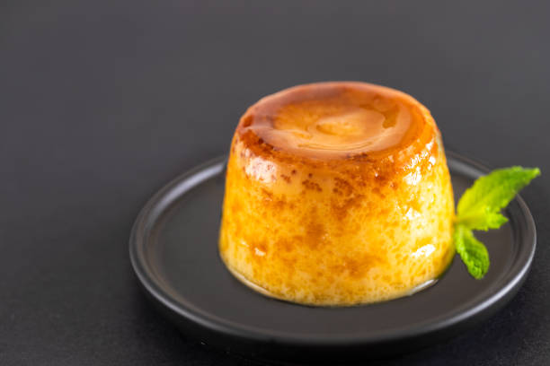 istock Creme caramel dessert or flan  decorated with mint on black background.Restourant menu image. Copy space. 1152447415
