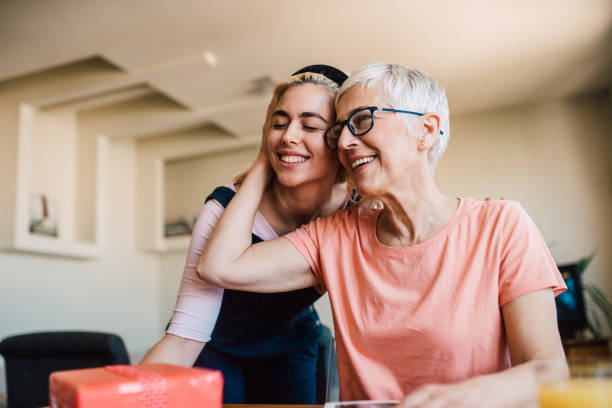 istock Mother hugging her daughter holding a gift 1152449621