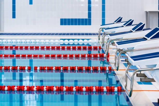 istock Swimming pool with marked red and white lanes. Empty swimming pool without people with quiet standing water. Water sports in indoor pool. 1152451254