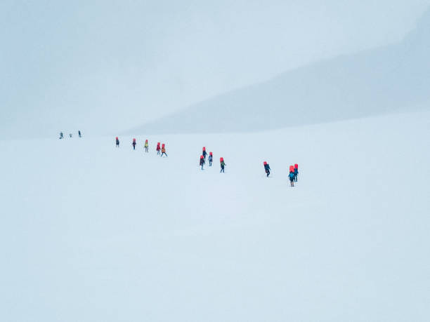 istock Hiking group walking on snowy trail in mountain 1152451268