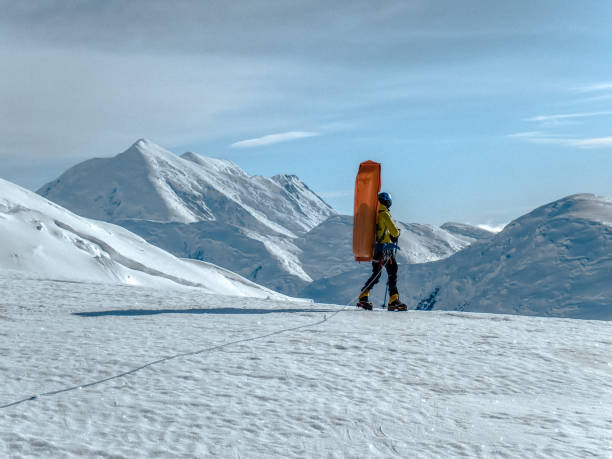 istock Man walking on snowy trail in mountain 1152451270