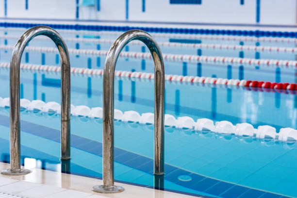 istock Swimming pool with marked red and white lanes. Empty swimming pool without people with quiet standing water. Water sports in indoor pool. 1152451300