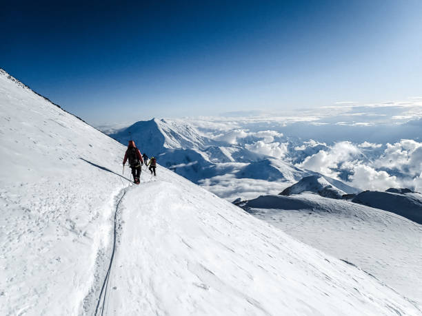 istock Hiking group walking on snowy trail in mountain 1152451653