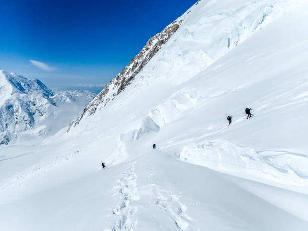 istock Hiking group walking on snowy trail in mountain 1152451731