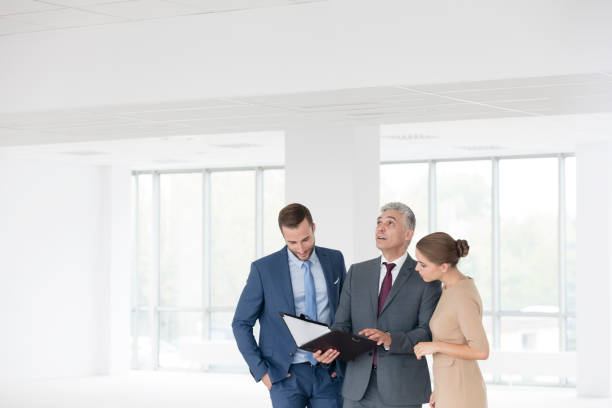 istock Confident mature business discussing over document with young colleagues at new office 1152453275