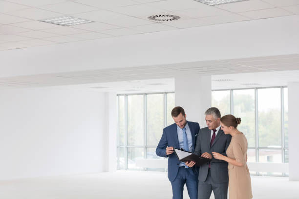 istock Confident business colleagues discussing over document at new office 1152456339