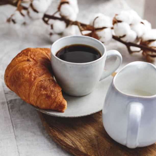 istock Breakfast table, a cup of black coffee with croissant and milk. 1152458434