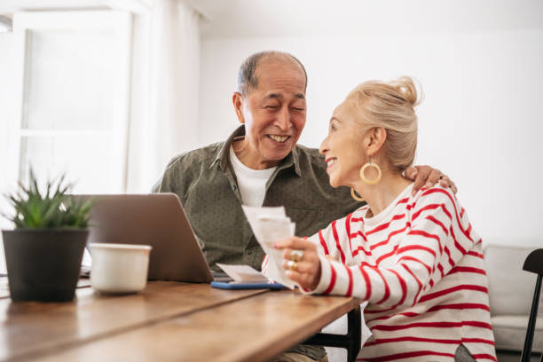 istock Senior couple working on home finances together and smiling 1152462577
