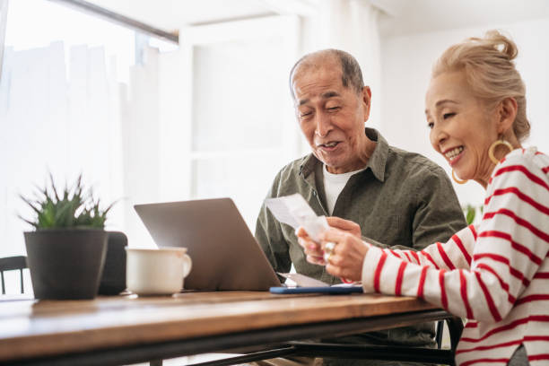 istock Cheerful senior couple looking at receipts and using laptop 1152463686