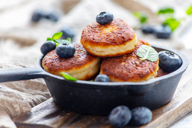 istock Cheese pancakes and blueberries in cast iron pan. 1152465238