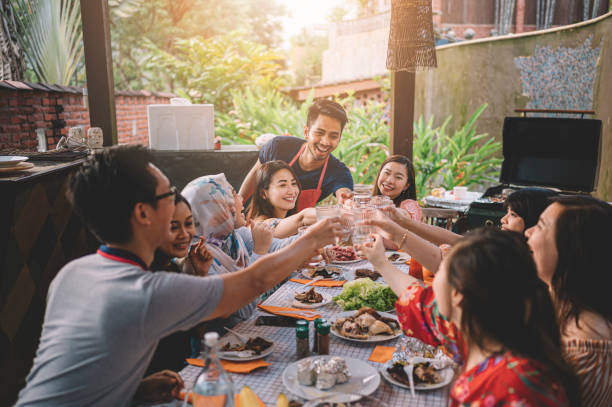 un grupo de amigos multi ética de ph que tienen un brindis de celebración en la zona de comedor en la villa durante el fin de semana escapada - cultura oriental fotografías e imágenes de stock