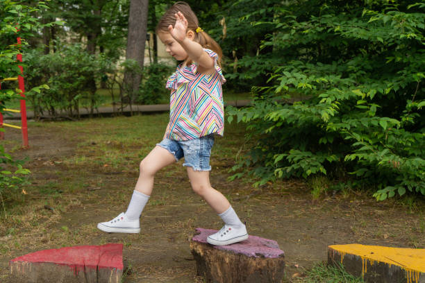 la niña está jugando en el patio de recreo, en armonía con la naturaleza eco-playground para niños - toddler child nature friendship fotografías e imágenes de stock