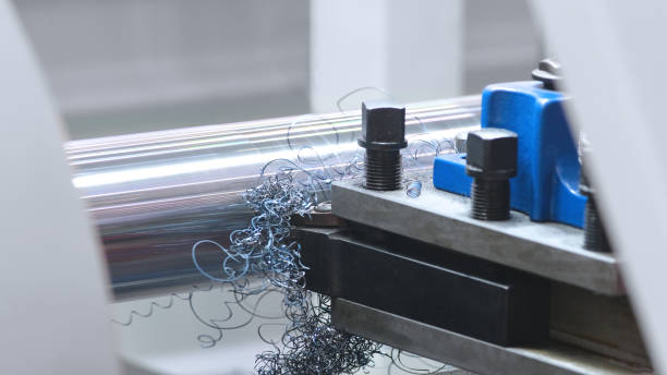 istock metalworking  industry: cutting steel metal shaft processing on lathe machine in workshop. Selective focus on tool 1152469143