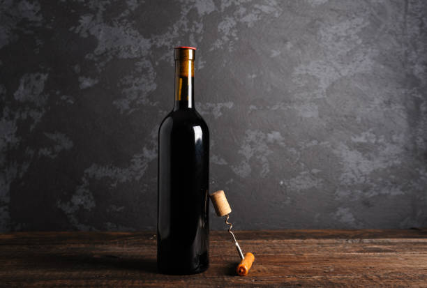 istock Red wine bottle on a wooden background 1152469338