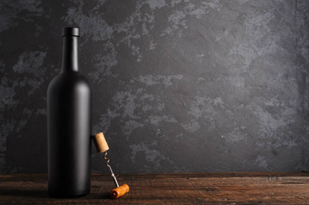 istock Red wine bottle on a wooden background 1152469346