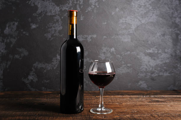 istock Red wine bottle on a wooden background 1152469350