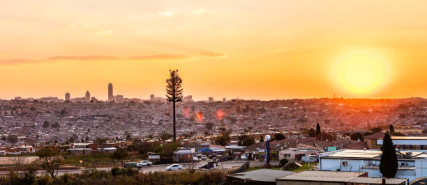 Alexandra Township panoramic sunset with Sandton City in the distance Cityscape of Alexandra Township at sunset in the evening with Sandton City skyscrapers seen in the distance. Alexandra also known as Alex was developed since 1912 and allocated for the africans in the apartheid era, it is now home to over 400 000 inhabitants in an area 7,6 km2, and forms part of Johannesburg city council. alexandra township photos stock pictures, royalty-free photos & images