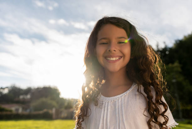 Portrait of a happy Latin American girl playing at the park and looking at the camera smiling - lifestyle concepts