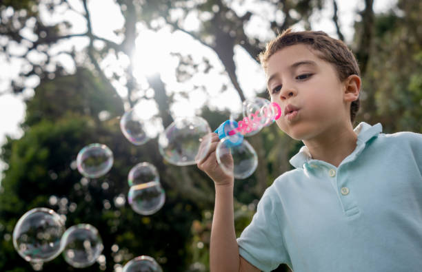 istock Portrait of a boy playing at the park making bubbles 1152470888