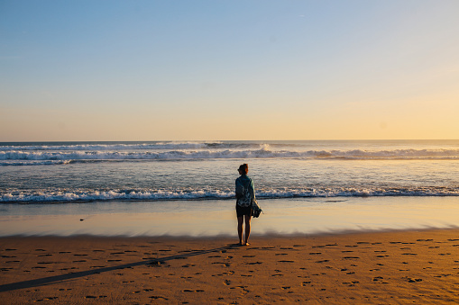 young tourist woman, enjoys walking on the sandy beaches of Bali, Indonesia. Wanderlust, solo traveler concepts in Southeast Asia.