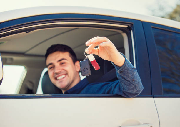 istock Positive smiling young man driver showing car keys out window. 1152470999