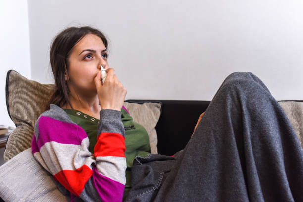 istock Young woman using an asthma inhaler 1152472124