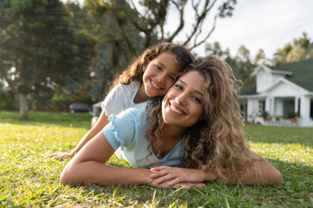 happy mother and daughter playing in the backyard of their house - spring happiness women latin american and hispanic ethnicity imagens e fotografias de stock