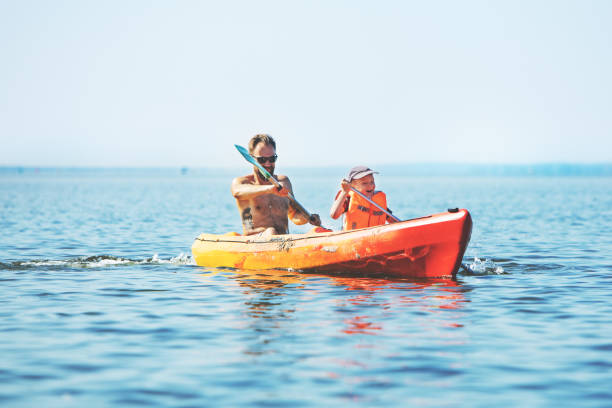 father and son rowing kayak on lake - family kayaking kayak canoeing imagens e fotografias de stock