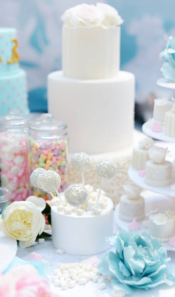 istock Traditional anniversary/wedding multi-layer cake decorated with flowers. And beautiful delicious sweet dessert - cupcakes, marshmallow, vanilla cake pops. 1152478705