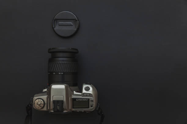 istock Photographer workplace with dslr camera system on dark black table background. Hobby travel photography concept 1152487106