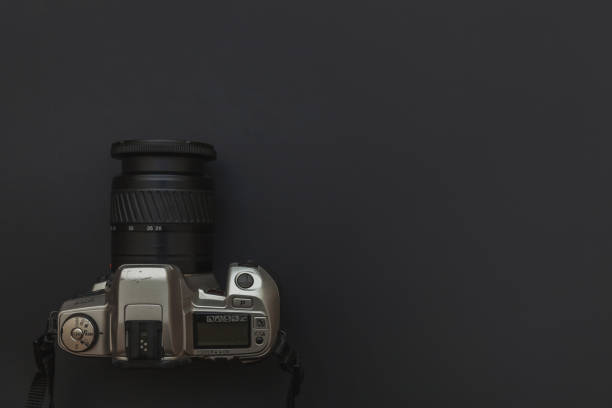 istock Photographer workplace with dslr camera system on dark black table background. Hobby travel photography concept 1152487130