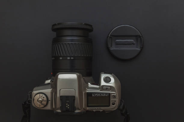 istock Photographer workplace with dslr camera system on dark black table background. Hobby travel photography concept 1152487152