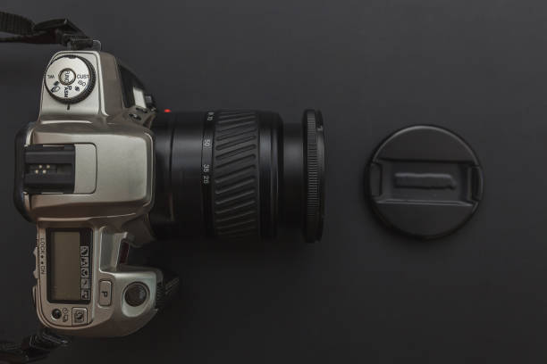 istock Photographer workplace with dslr camera system on dark black table background. Hobby travel photography concept 1152487175