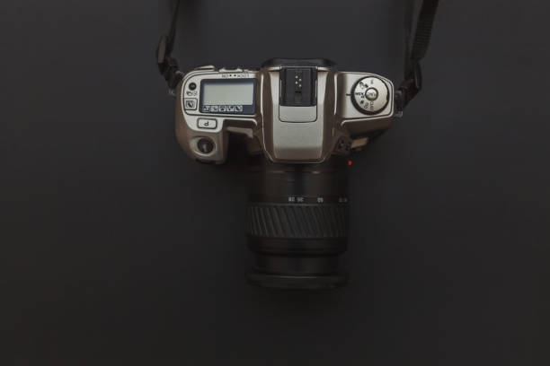 istock Photographer workplace with dslr camera system on dark black table background. Hobby travel photography concept 1152487229