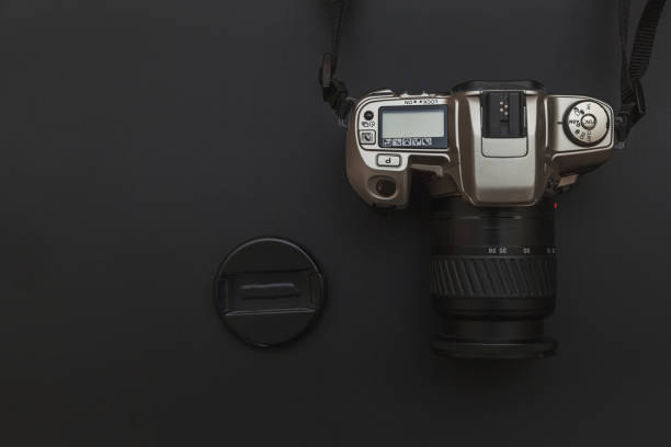istock Photographer workplace with dslr camera system on dark black table background. Hobby travel photography concept 1152487247