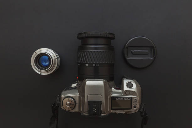 istock Photographer workplace with dslr camera system and lens on dark black table background. Hobby travel photography concept 1152487281