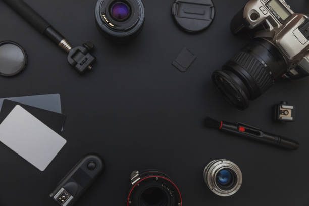 istock Photographer workplace with dslr camera system, camera cleaning kit, lens and camera accessory on dark black table background 1152487345